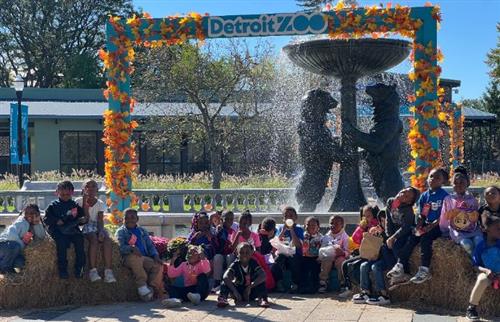  1st grade class of studetns sitting outside by the waterfountain at the detroit zoo